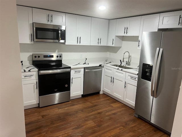 kitchen with stainless steel appliances, white cabinetry, dark wood-type flooring, and sink