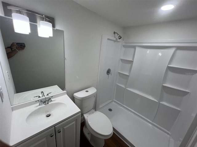 bathroom with vanity, a shower, toilet, and wood-type flooring