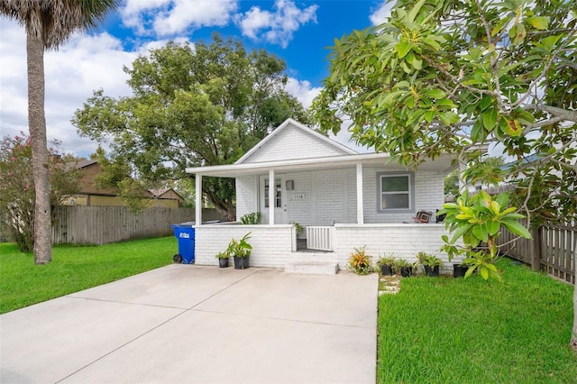 bungalow-style home with brick siding, a porch, fence private yard, and a front yard