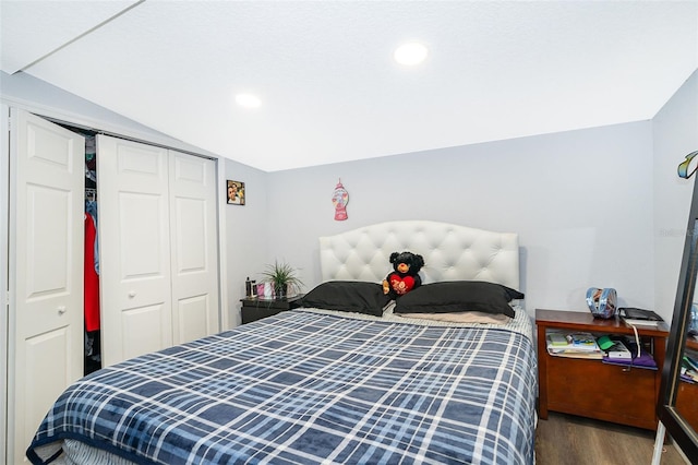 bedroom with vaulted ceiling, recessed lighting, wood finished floors, and a closet