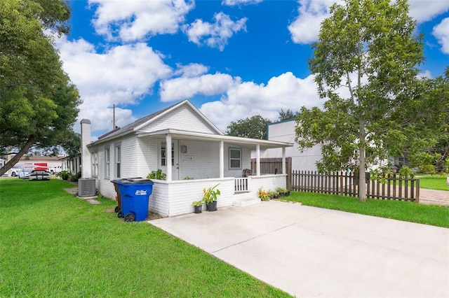 view of front of property with central AC, covered porch, and a front lawn