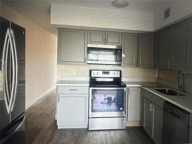 kitchen with stainless steel appliances, dark hardwood / wood-style flooring, and sink