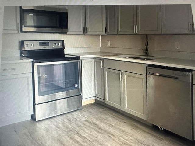 kitchen with light hardwood / wood-style flooring, stainless steel appliances, and sink