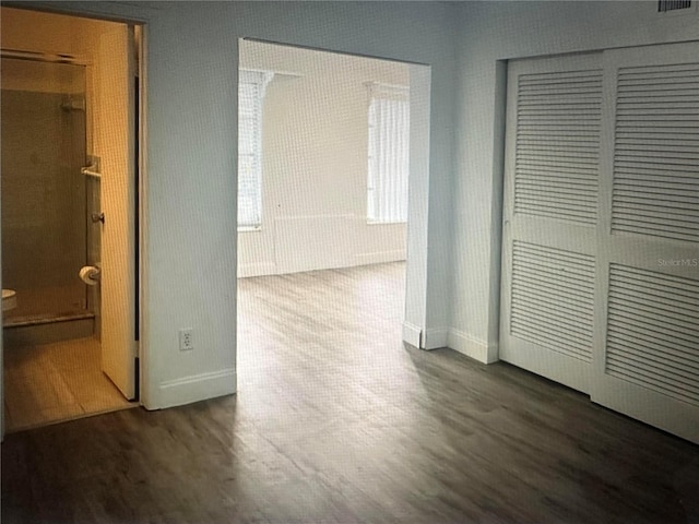 corridor with dark hardwood / wood-style flooring