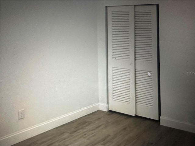 unfurnished bedroom featuring a closet and dark hardwood / wood-style floors