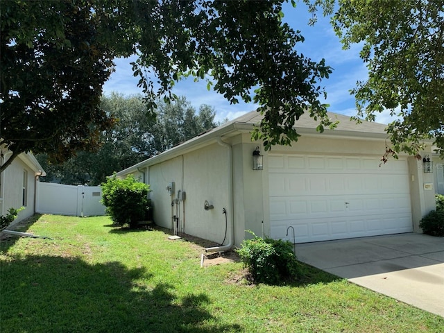 view of property exterior with a garage and a lawn