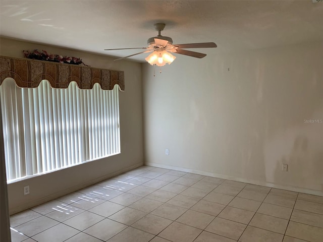 tiled empty room featuring ceiling fan