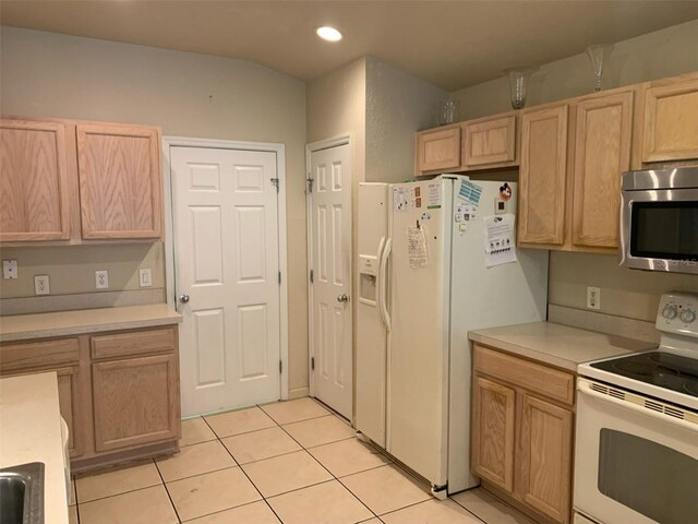 kitchen featuring white appliances, light brown cabinetry, and light tile patterned flooring