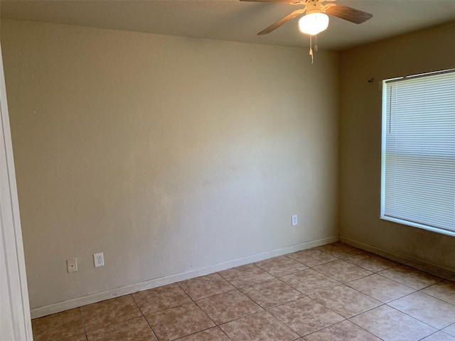 tiled empty room featuring ceiling fan