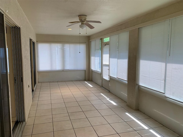 unfurnished sunroom featuring ceiling fan