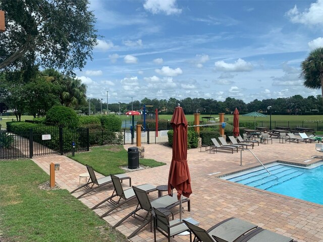 view of pool with a lawn and a patio area