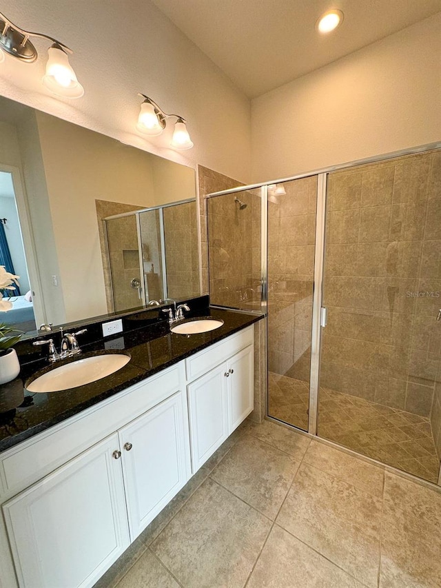 bathroom with tile patterned floors, a shower with door, and vanity