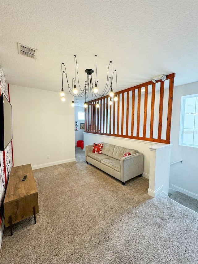 living room with carpet flooring, a chandelier, and a textured ceiling