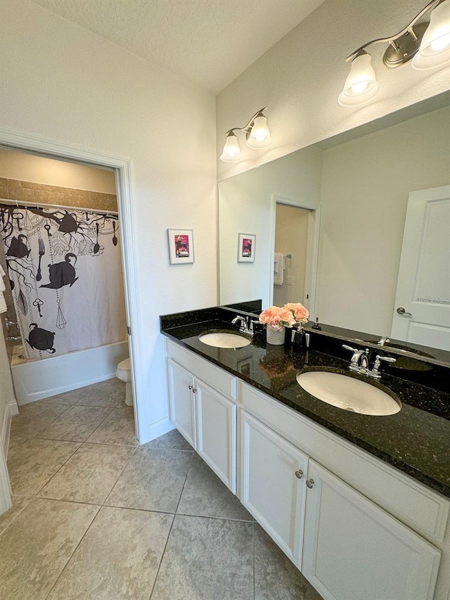 full bathroom with a textured ceiling, vanity, shower / bath combination with curtain, toilet, and tile patterned floors