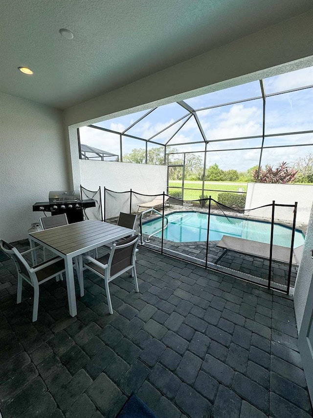 view of swimming pool featuring a lanai, grilling area, and a patio area