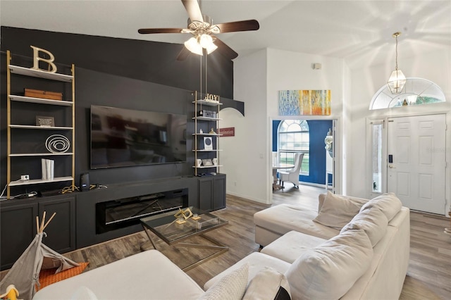 living room with hardwood / wood-style floors, ceiling fan, and vaulted ceiling