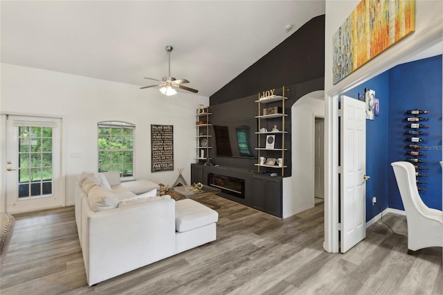 living room with hardwood / wood-style floors, ceiling fan, and high vaulted ceiling