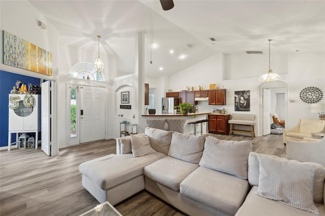 living room with high vaulted ceiling and hardwood / wood-style floors