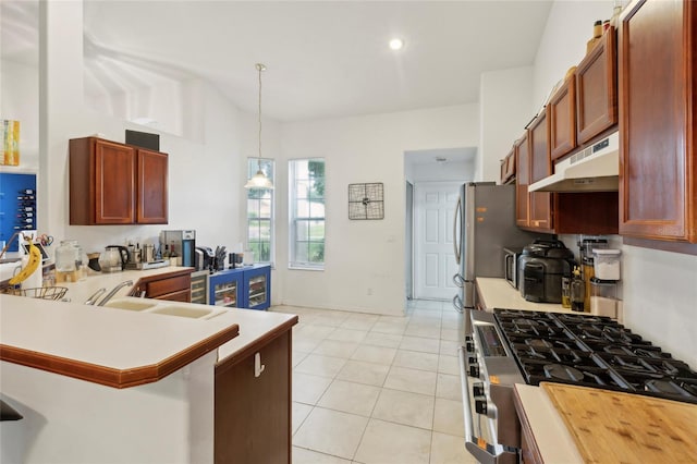 kitchen with sink, kitchen peninsula, light tile patterned floors, decorative light fixtures, and stainless steel gas stove