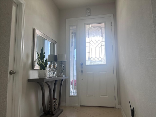 entryway with light tile patterned flooring and baseboards