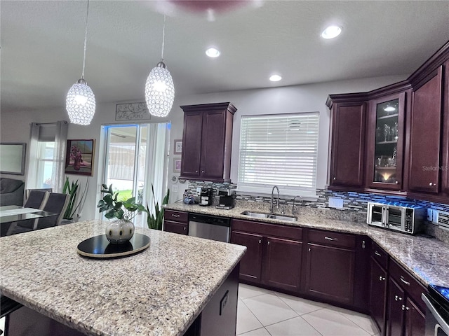 kitchen with tasteful backsplash, light stone counters, stainless steel appliances, and a sink