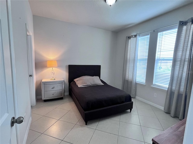 bedroom featuring light tile patterned floors and baseboards