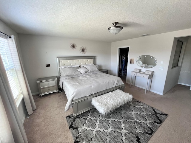 carpeted bedroom featuring baseboards, visible vents, and a textured ceiling