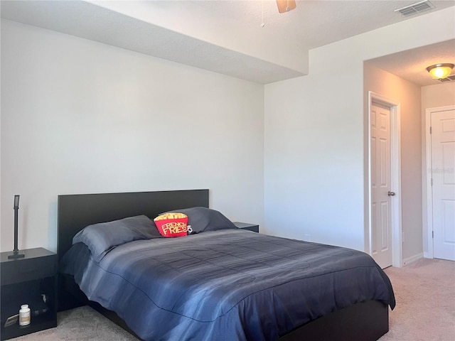 bedroom with baseboards, visible vents, ceiling fan, and light colored carpet