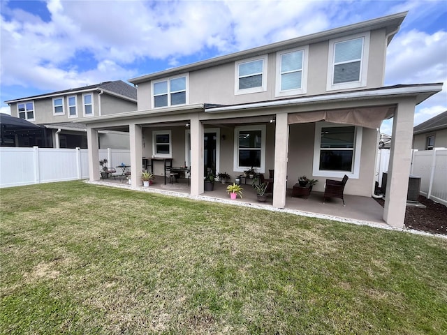 back of house with central AC unit, fence, a lawn, stucco siding, and a patio area