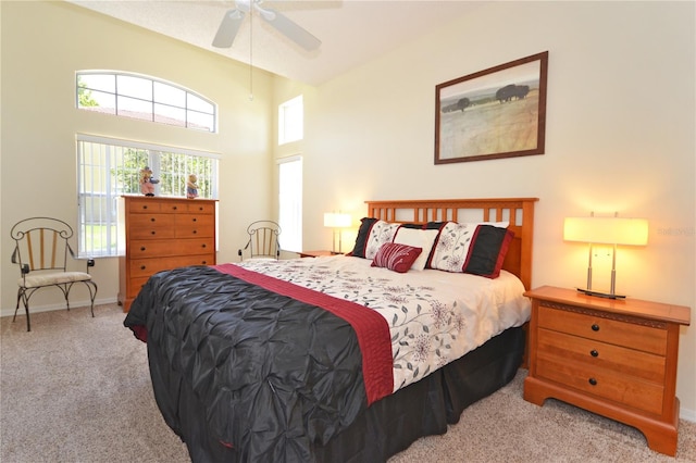 bedroom with a high ceiling, ceiling fan, and light colored carpet