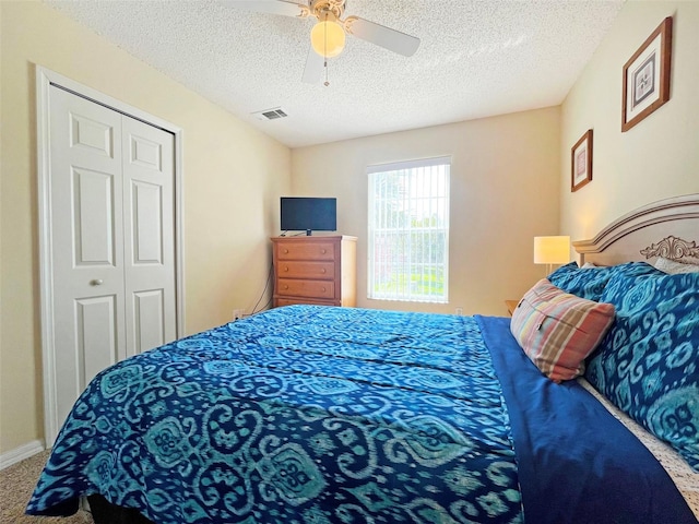 bedroom with carpet flooring, a closet, ceiling fan, and a textured ceiling