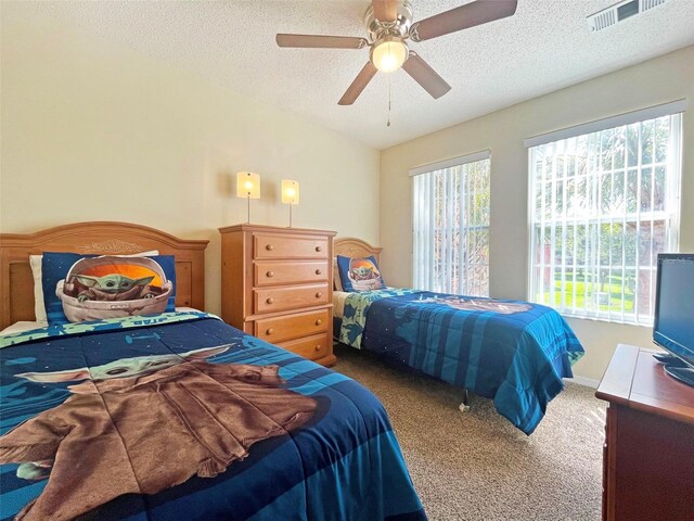 bedroom featuring ceiling fan, carpet flooring, and a textured ceiling