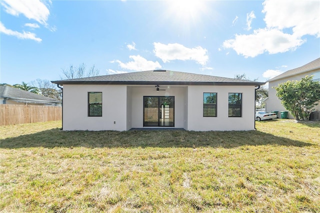 back of property with a lawn, ceiling fan, and central air condition unit