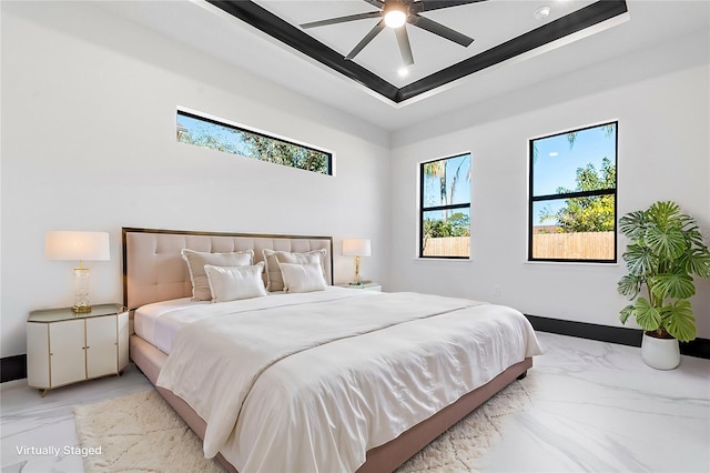 bedroom with a raised ceiling and ceiling fan