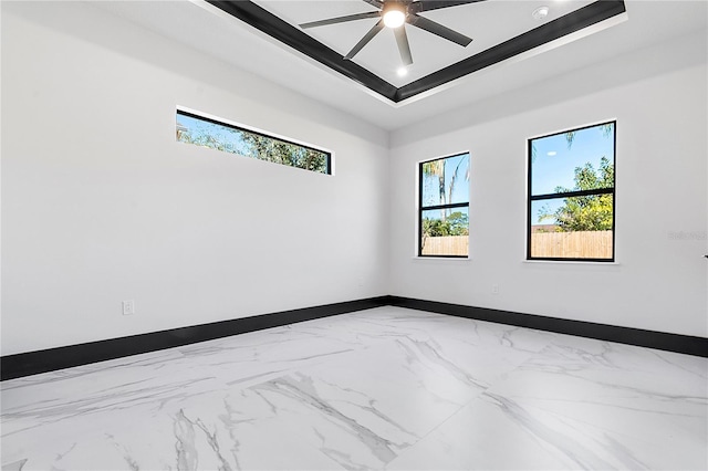 spare room with a raised ceiling and ceiling fan