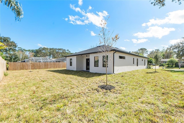 rear view of property featuring a lawn