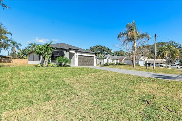 ranch-style home with a garage and a front lawn