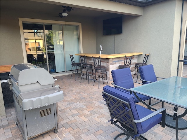 view of patio featuring a bar, ceiling fan, and a grill