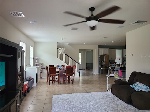 living room featuring a healthy amount of sunlight, light tile patterned floors, and ceiling fan