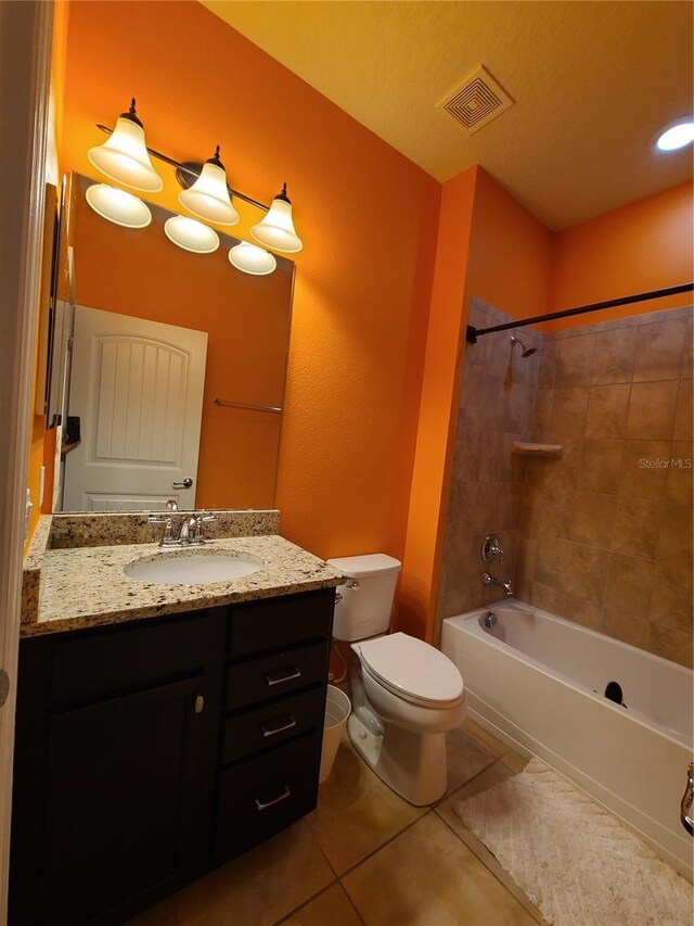 full bathroom featuring tiled shower / bath, vanity, toilet, and tile patterned flooring