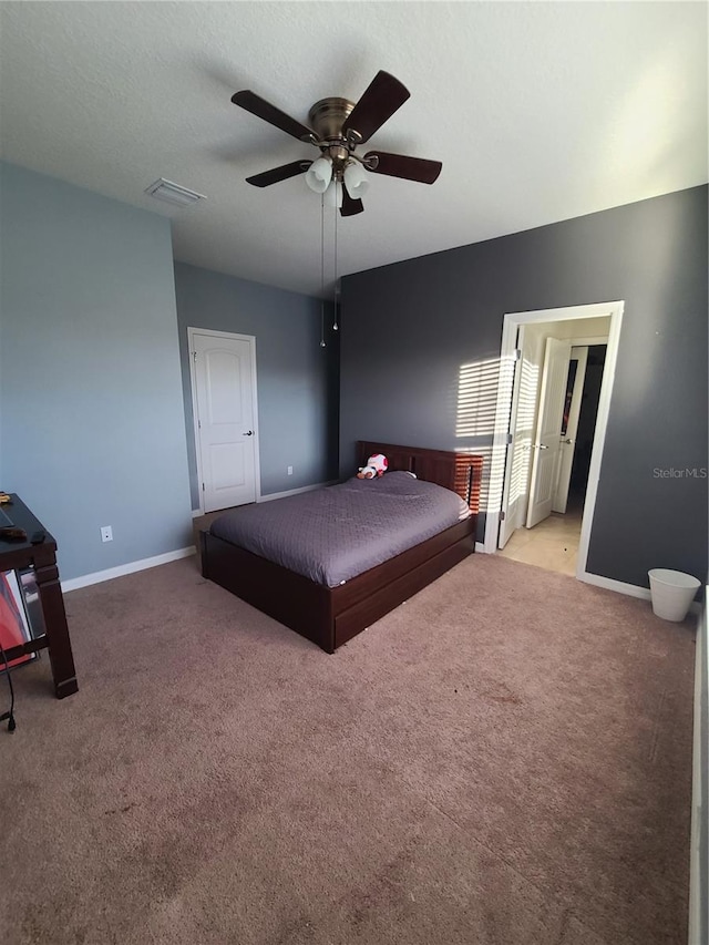 unfurnished bedroom with light carpet, a textured ceiling, and ceiling fan