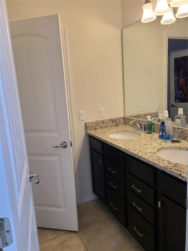 bathroom with an inviting chandelier, vanity, and tile patterned flooring