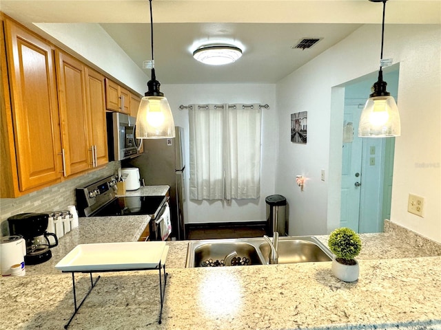 kitchen featuring pendant lighting, sink, and appliances with stainless steel finishes