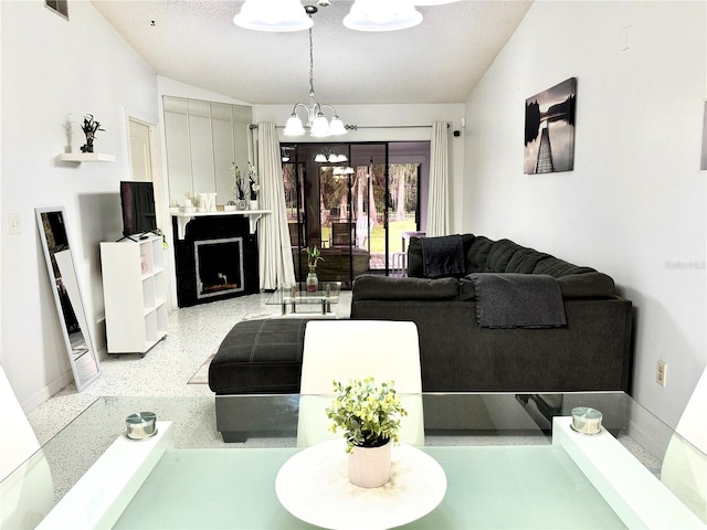 living room with a fireplace, a textured ceiling, and a notable chandelier