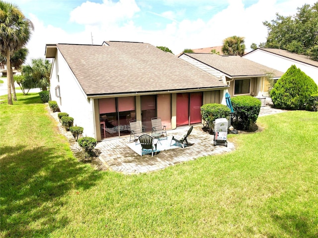 rear view of house featuring a yard and a patio area