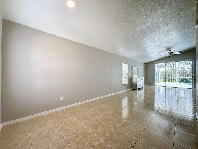 unfurnished room featuring lofted ceiling, ceiling fan, a textured ceiling, and light tile patterned flooring