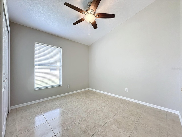 empty room featuring a textured ceiling, ceiling fan, light tile patterned floors, and vaulted ceiling