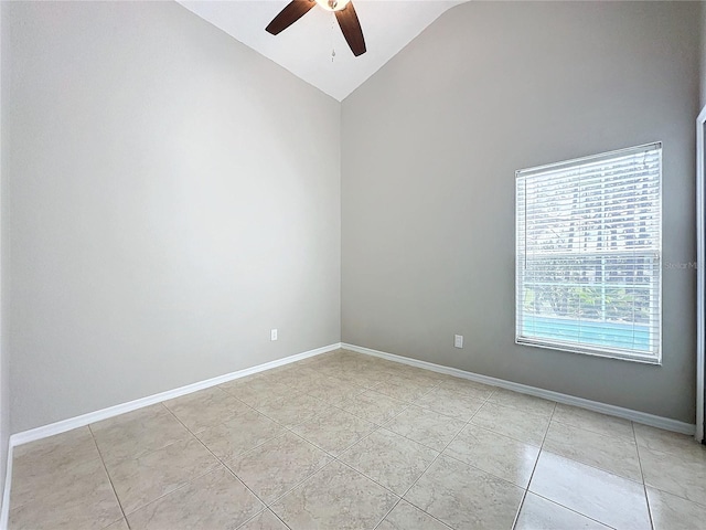 empty room with lofted ceiling, ceiling fan, and light tile patterned floors