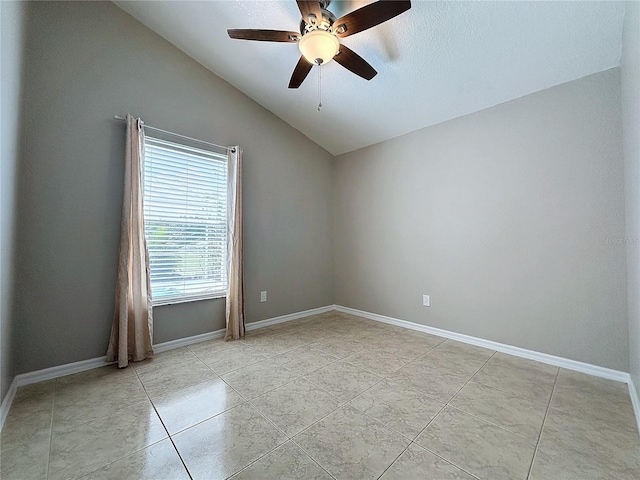 spare room with lofted ceiling, ceiling fan, light tile patterned floors, and a textured ceiling