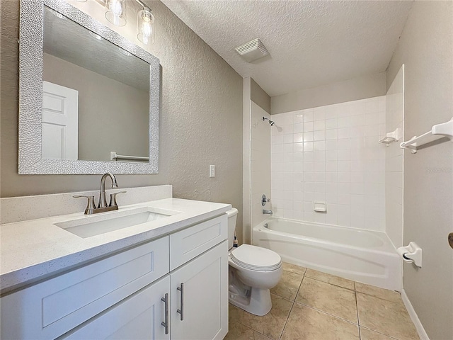 full bathroom with toilet, tile patterned floors, vanity, a textured ceiling, and tiled shower / bath combo